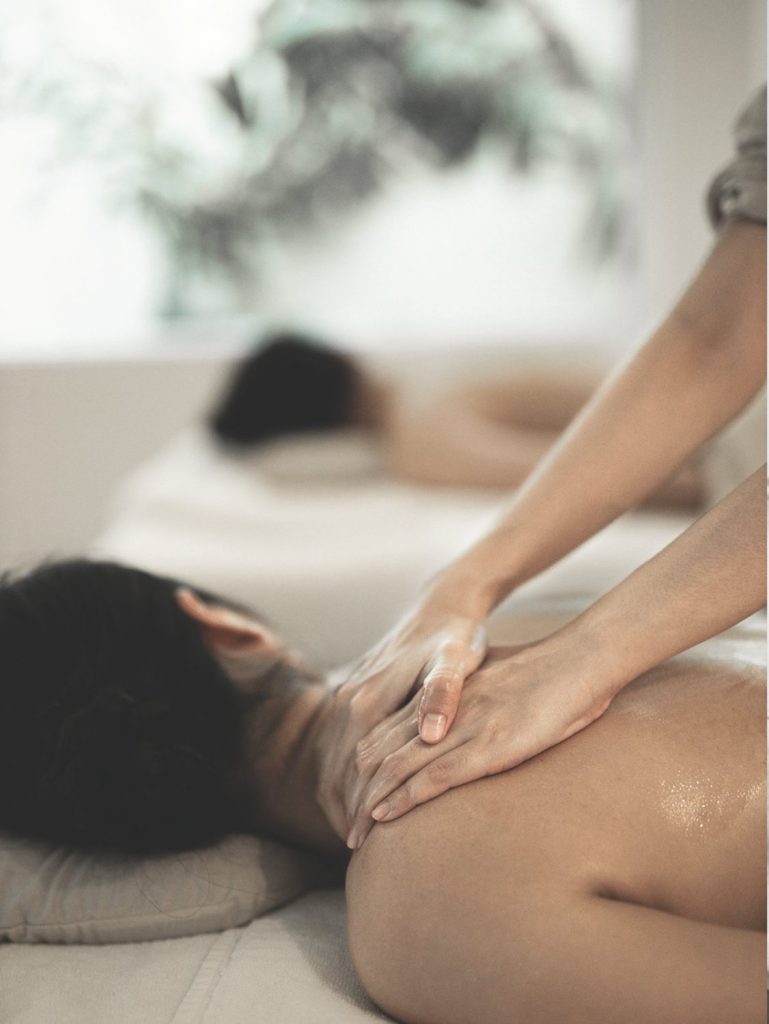 Young women receiving a Thai massage at a spa in Thailand. This can improve mental health.